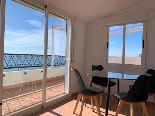 a dining room with a table and chairs and a balcony at Como en Casa 2 PARKING in Santa Pola