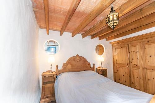 a bedroom with a bed and a wooden ceiling at Finca Rosalia in Cómpeta