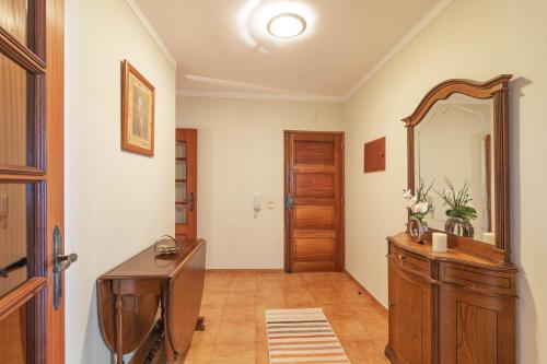 a bathroom with a mirror and a wooden dresser at Quarteira CONDESTÁVEL T3 in Quarteira