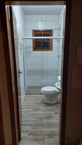 a bathroom with a toilet and a glass shower at Morada da Serra Alta in São Francisco de Paula