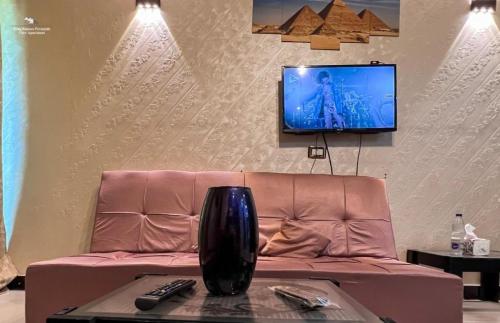 un soggiorno con divano e TV a parete di Ramses Pyramids View Apartment a Il Cairo