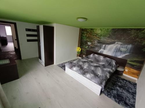 een slaapkamer met een bed en een schilderij aan de muur bij Vila Adelina in Buşteni