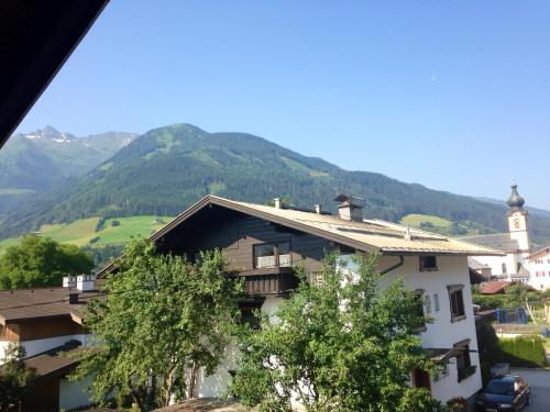 a house in a village with mountains in the background at Pension Kuntschner in Mittersill