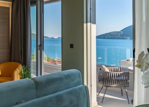 a living room with a blue couch and a view of the ocean at Garni Hotel Kruso in Herceg-Novi