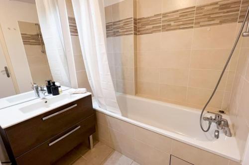 ein Badezimmer mit einem Waschbecken, einer Badewanne und einer Dusche in der Unterkunft La Plaine St Denis, Paris Stade de France in Saint-Denis