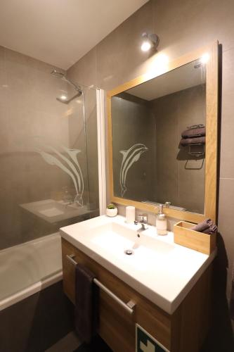 uma casa de banho com um lavatório, um espelho e uma banheira em Highrise Madalenas Apartment no Funchal