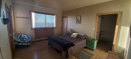 Habitación pequeña con cama y ventana en Casona El Faro, en San Antonio