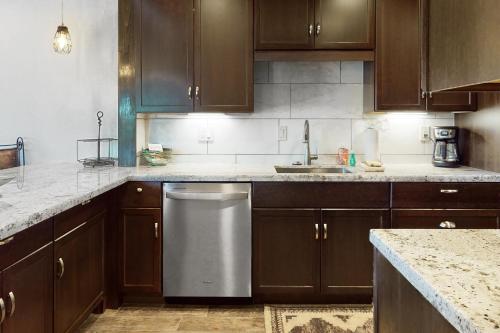 a kitchen with wooden cabinets and a stainless steel dishwasher at Tranquil Trail #6 in Carefree
