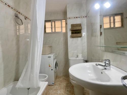 een witte badkamer met een wastafel en een toilet bij Caballos Levante Beach in Benidorm