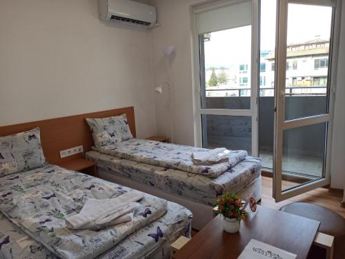 Habitación pequeña con 2 camas y mesa. en Gabrovo Relax Apartment, en Gabrovo