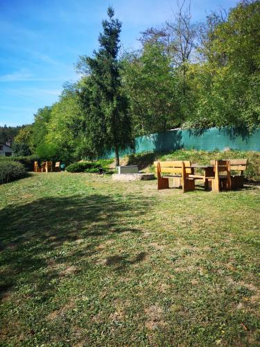 a group of wooden picnic tables in a park at Apartmán U vody in Županovice