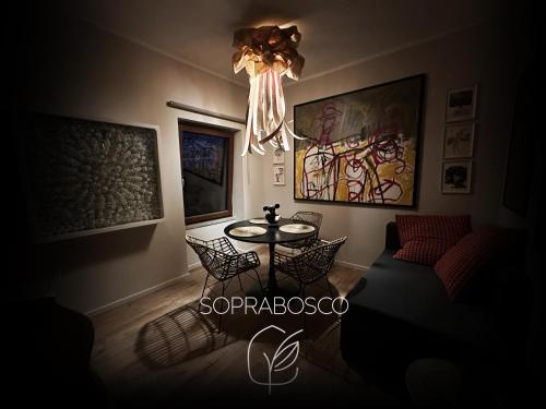 a room with a table and chairs and a chandelier at SopraBosco Calcata Art & Design Apartment in Calcata