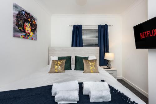 Un dormitorio con una cama grande con dos almohadas. en King Beds - Smart TVs - Parking - Near City, en Swansea