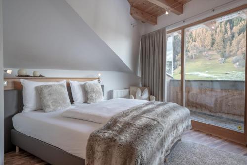 Schlafzimmer mit einem Bett und einem großen Fenster in der Unterkunft Petit madlein in Ischgl
