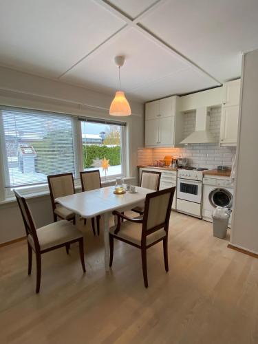 a kitchen with a dining room table and chairs at Gardermoen House in Gardermoen