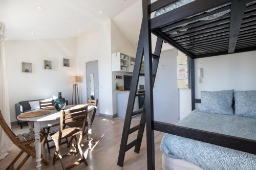 een kamer met een eettafel en een stapelbed bij L'Isle en Blanc - Appartement hypercentre - 4 couchages in LʼIsle-sur-la-Sorgue