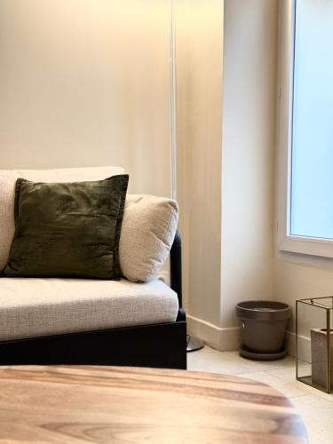 - un salon avec un canapé et un oreiller vert dans l'établissement Superbe loft Pigalle / Opéra, à Paris