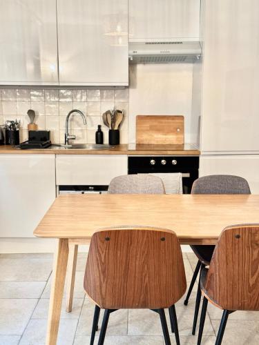 une cuisine avec une table et des chaises en bois dans l'établissement Superbe loft Pigalle / Opéra, à Paris