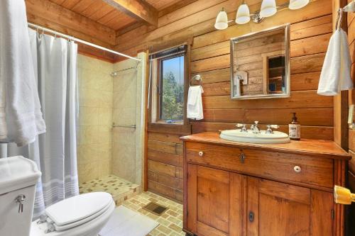 baño de madera con lavabo y aseo en Cousins River Sanctuary, en Martindale