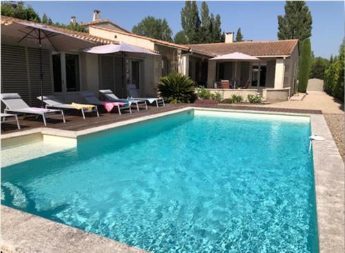 une piscine bleue devant une maison dans l'établissement Villa Castillon, à Paradou