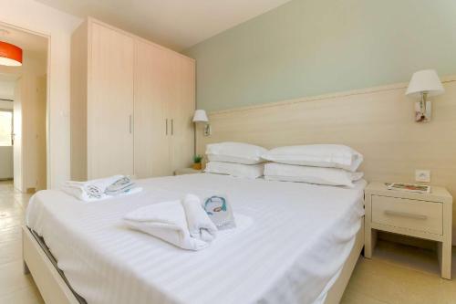 une chambre avec un grand lit blanc avec des serviettes dessus dans l'établissement SELECT'SO HOME - Résidence Le Poséidon - Piscine & Garage - Prestations de qualité & Services Hôteliers - POS22, à Bormes-les-Mimosas