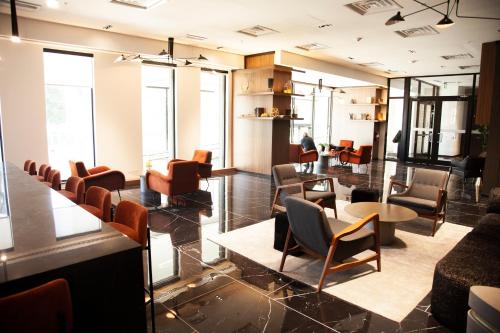 a waiting room with chairs and tables and windows at The Laundry Rooms - Waterloo in Waterloo
