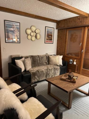 a living room with a couch and a table at Grand studio à Ovronnaz in Ovronnaz