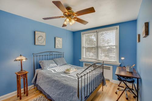 1 dormitorio con paredes azules y 1 cama con ventilador de techo. en Quaint Lansdowne Getaway Near Downtown Philly!, en Lansdowne
