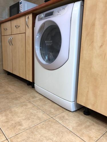 a white washing machine is sitting in a kitchen at Adrian Home 3 rooms apartment in Ploieşti
