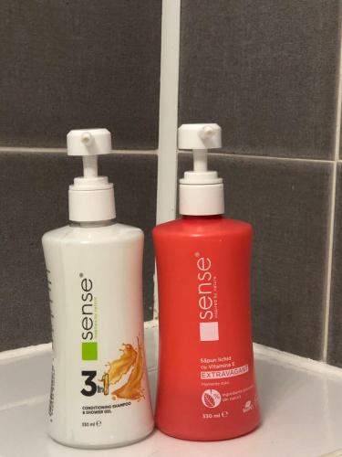 two bottles ofodorizers are sitting on a bathroom sink at Adrian Home 3 rooms apartment in Ploieşti