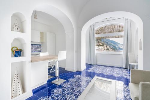 cocina con suelo de baldosa azul y ventana en Villa Magia en Positano