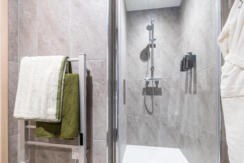 a bathroom with a shower with a glass door at Elegant central apartment 3 in Milton Keynes