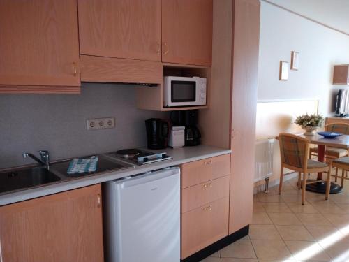 a small kitchen with a sink and a dishwasher at Hotel Esplanade & Aparthotel Rialto in Binz