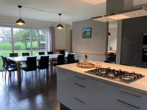 a kitchen and dining room with a table and a stove at De Smokkelaar & Het Schuurtje in Maldegem
