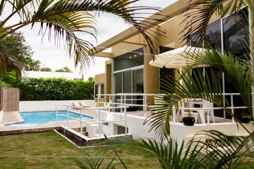 uma casa com piscina ao lado de uma casa em Lagos del Peñon, Casa Arena em Girardot