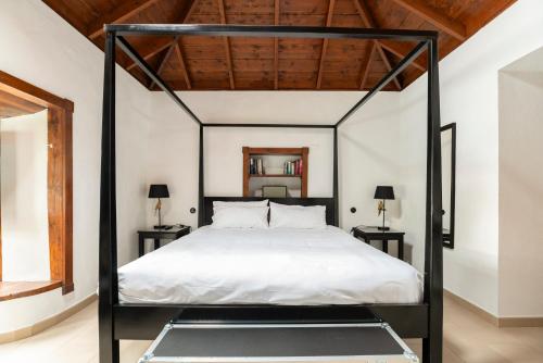 a bedroom with a black canopy bed with white sheets at The El Paso in El Paso