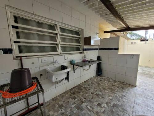 a bathroom with a sink in a room with at Casa a 5 minutos a pé da Praia da Enseada! in Bertioga