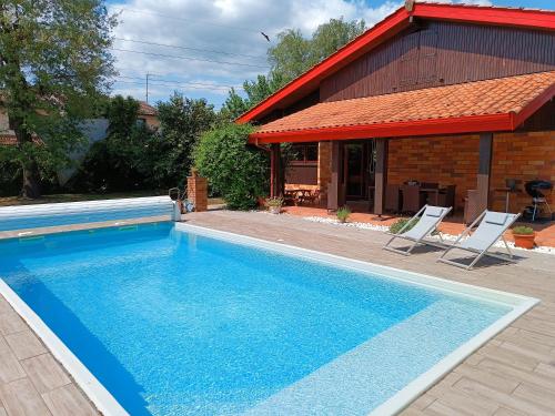 - une piscine avec 2 chaises et une maison dans l'établissement MagHouse, à Cestas