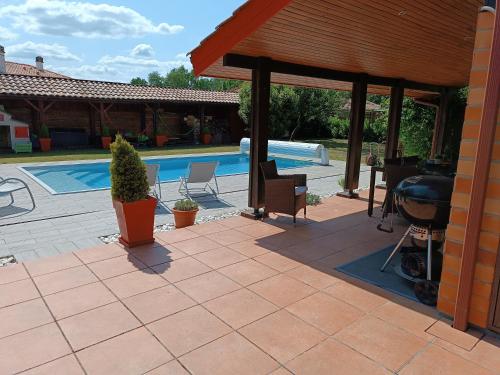 a patio with a grill and a swimming pool at MagHouse in Cestas