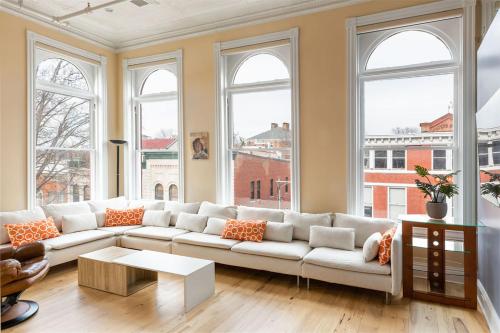 a living room with a white couch and windows at Penthouse Apartment Overlooking Downtown Mall in Charlottesville