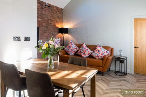 a living room with a couch and a table with flowers at Station Cottage in North Berwick