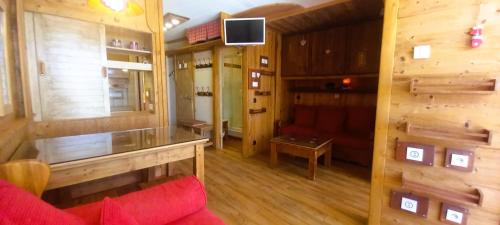 un salon avec un canapé rouge et une télévision dans l'établissement Mountain dream family, aux Menuires