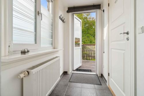 a hallway with a white door and a window at Cozy Holiday Apartment In Allinge in Allinge