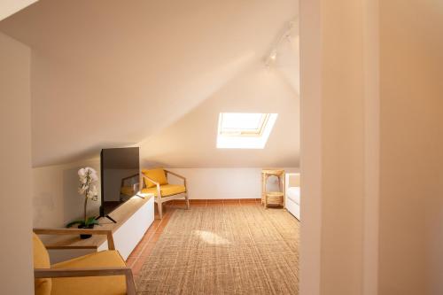 a attic room with a skylight and a living room at RMR Charme & Vistas @ T3 Duplex in Tavira