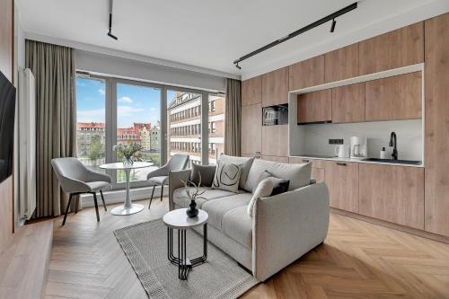 a living room with a couch and a table at Flatbook - City Center Apartments Granaria in Gdańsk