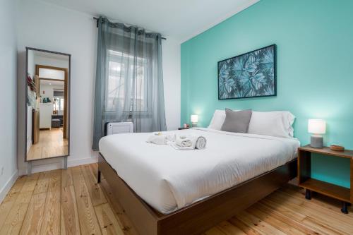 una camera con un grande letto con una parete blu di BeGuest Bright Inn Lisbon Apartment a Lisbona