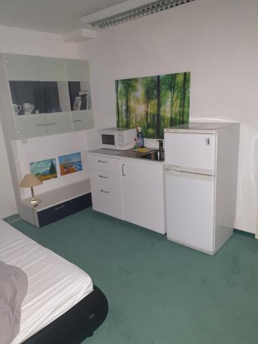 een witte keuken met een wastafel en een koelkast bij 4you in Berlijn
