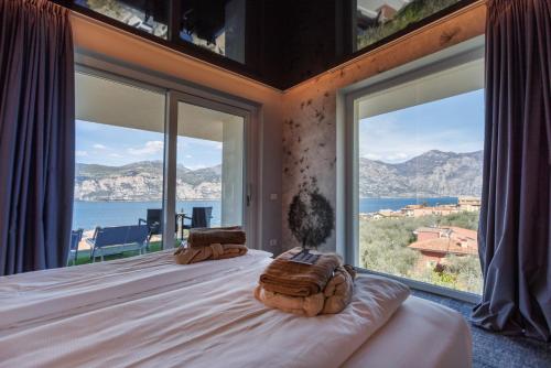 a bedroom with a bed with a view of the ocean at Wellness Hotel Casa Barca (Adult Only) in Malcesine