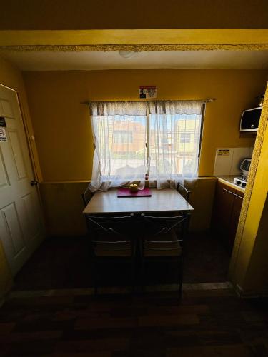 una pequeña cocina con mesa y ventana en Habitaciones con baño compartido, en Calama