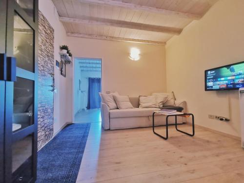 uma sala de estar com um sofá e uma televisão em Bilocale in centro storico a Bertinoro em Bertinoro